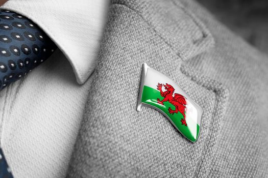 Metal badge with the flag of Wales on a suit lapel.