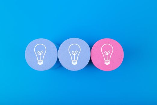 Concept of idea, creativity, start up or brainstorming. White drawn bulbs on blue and pink circles against blue background