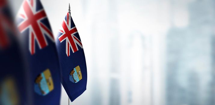 Small flags of Saint Helena on a blurry background of the city.