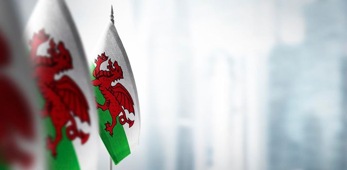 Small flags of Wales on a blurry background of the city.