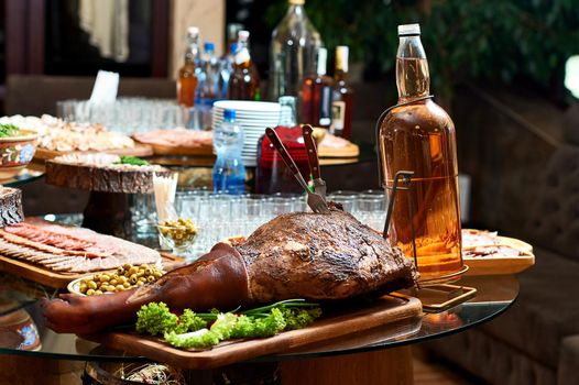 Close up of a restaurant table. Smoked pork served on a wooden plate.