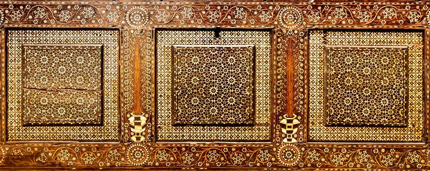 Antique art of wood decoration on a 15th century Italian furniture. Vintage and gothic background image.