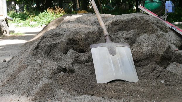 The shovel for dripping is lying on the pile of dry concrete or cement, construction and development concept.