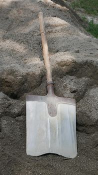 The shovel for dripping is lying on the pile of dry concrete or cement, construction and development concept.