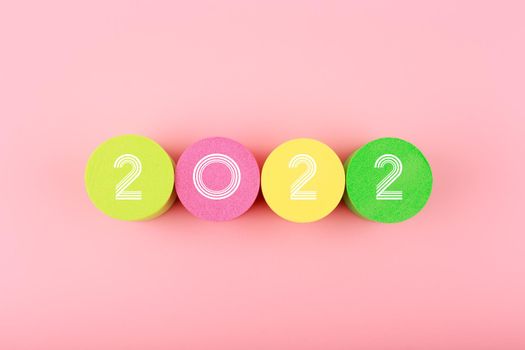 2022 numbers on colorful circles in the middle of bright pink background. Minimal trendy concept of New 2022 Year 