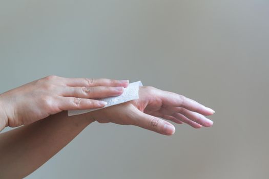 Woman cleaning her hands with white soft tissue paper. isolated on a white backgrounds