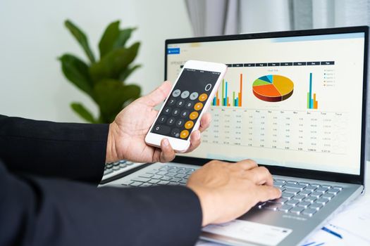 Asian accountant working and analyzing financial reports project accounting with chart graph and calculator in modern office, finance and business concept.