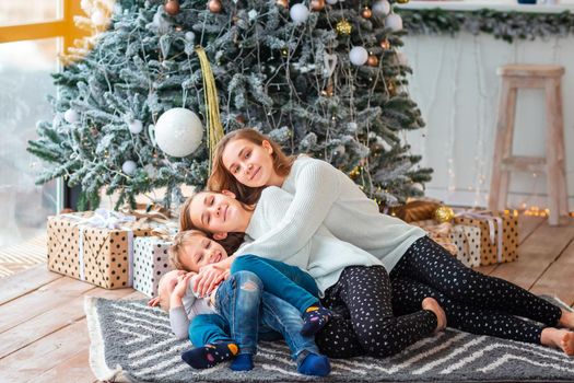 Happy kids sibilings near the Christmas tree with the present boxes. Christmas morning, christmas mood concept