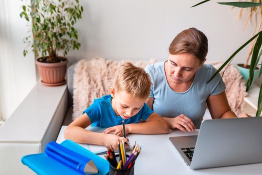 Mother with kid trying to work from home during quarantine. Stay at home, work from home concept during coronavirus pandemic