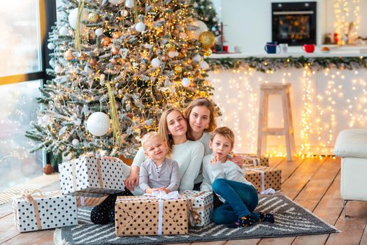 Happy kids sibilings near the Christmas tree with the present boxes. Christmas morning, christmas mood concept