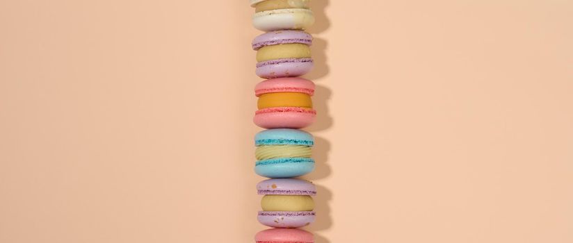 baked round macarons on a beige background, delicious dessert, top view