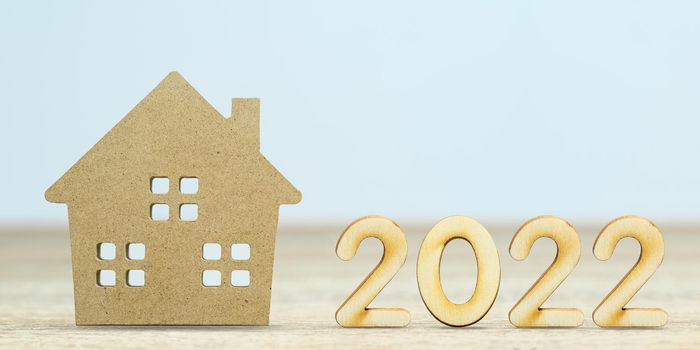 Wooden numeric new year 2022 house model on table with copy space