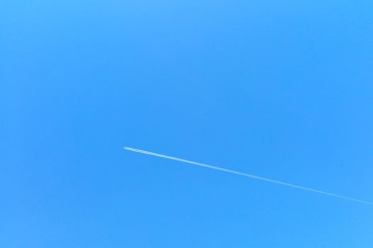 Out of focus, a plane flies against the blue sky