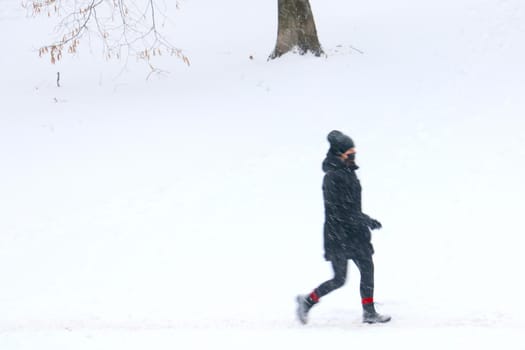 Out of focus, blurry background, a person goes on a snowy winter day. Bad weather