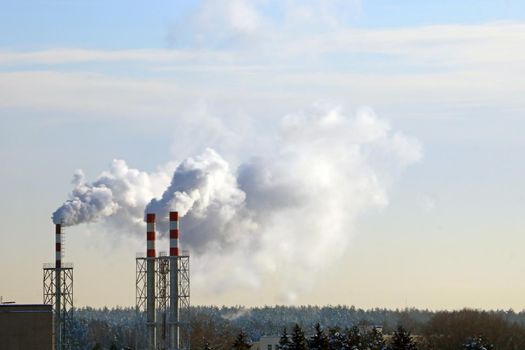 From the chimney there is smoke in winter against the sky