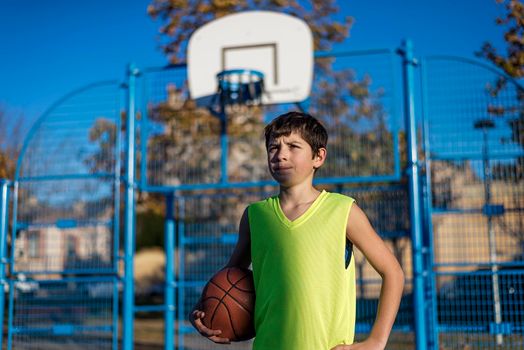 A Teenage boy holding a basketball on a court