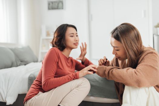 Two female friends do a manicure