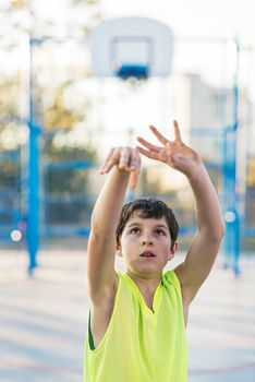 A Teenage playing basketball on an outdoors court