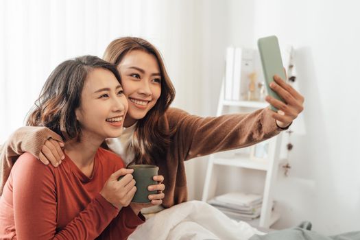 Young Asian Girls doing selfie on the bed