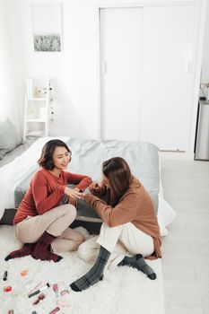 Women applying nail polish at home