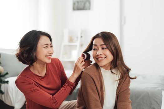 Smiling Two Asian young lovely couple sitting on white bed and happy.