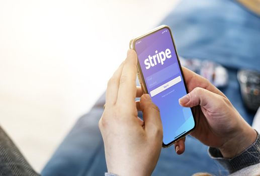 San Francisco, CA, USA, March 15, 2021: Woman holding a smart phone with Stripe app on the screen. Stripe is an American financial services company. Business and finance