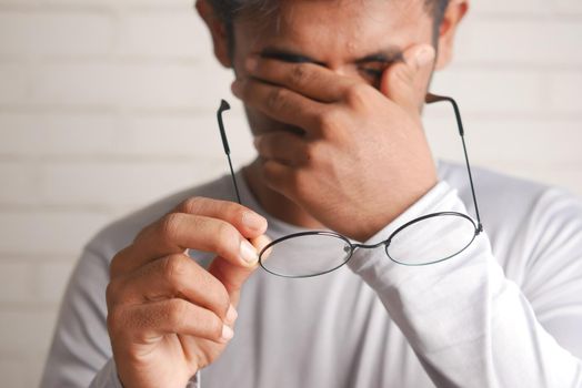 Close up of upset man suffering from strong eye pain.