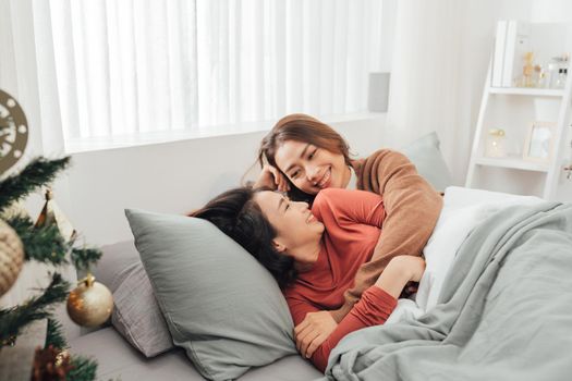 Young couple smiling happy and hugging sitting on the bed.