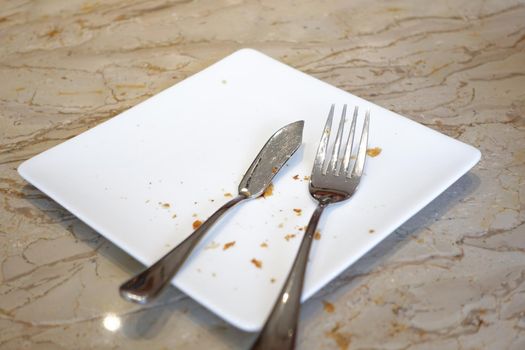 cutlery and empty plate on wooden background