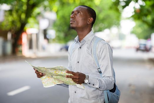 young tourist man looking for his landmarks with a map in the city. Tourism concept. Outside.