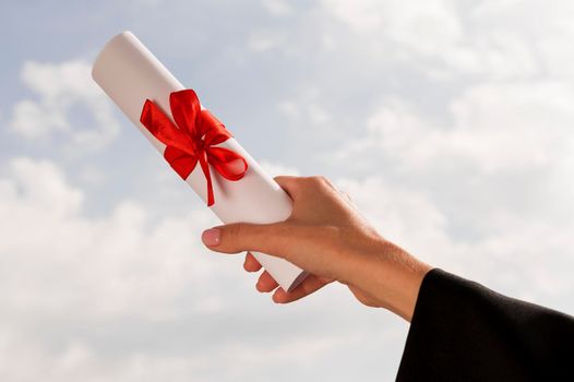 certificate with ribbon bow held hand. High resolution photo