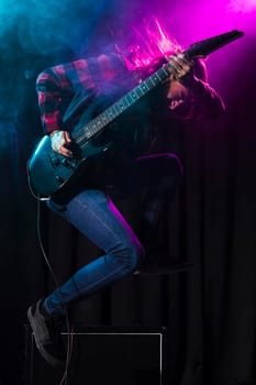artist playing guitar jumping sideways. High resolution photo