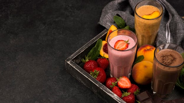 high angle milkshake glasses tray with chocolate fruits. Beautiful photo