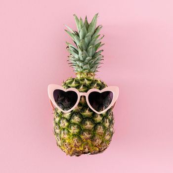 top view pineapple with heart shaped sunglasses. Beautiful photo