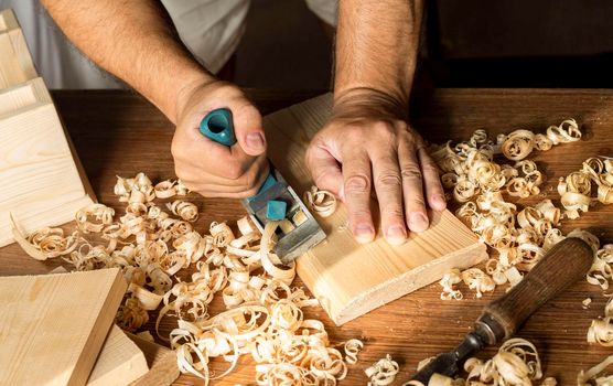 carpenter working with his bare hands wood. High resolution photo