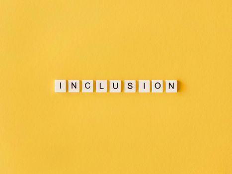inclusion word written scrabble letters yellow background. High resolution photo