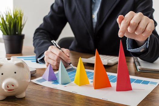 front view businessman with colorful cones representing growth. Resolution and high quality beautiful photo