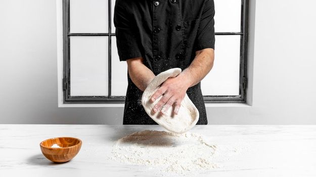 front view man kneading pizza dough. High resolution photo