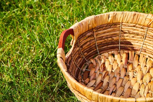 Image of Empty woven basket sitting in field of grass