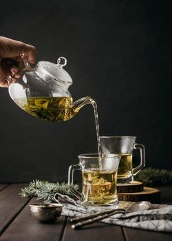 front view hand pouring tea glass with teapot. Beautiful photo