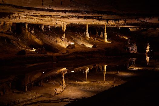 Image of Large reflective pond that looks like a mirror in cave with stalagmites and stalactites