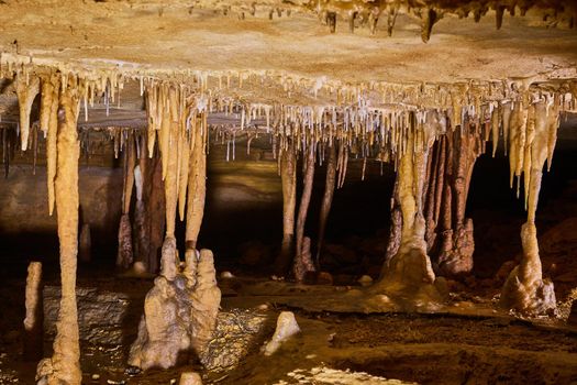 Image of Low cave tunnel with formations of stalagmites and stalactites