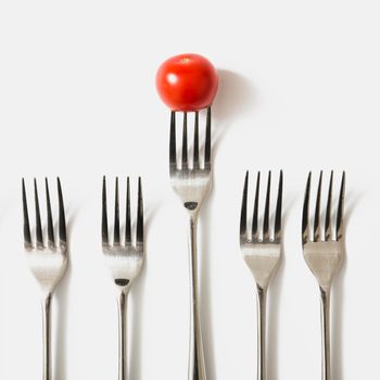 red cherry tomato fork against white background. Beautiful photo