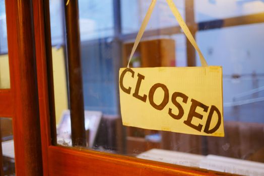 closed sign hanging on door of cafe