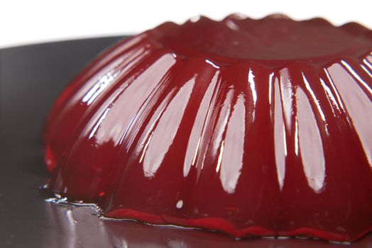 close up of red jelly on plate on table