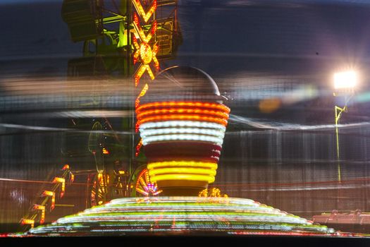 Image of Yellow, red and white spinning together on a carnival or fair ride