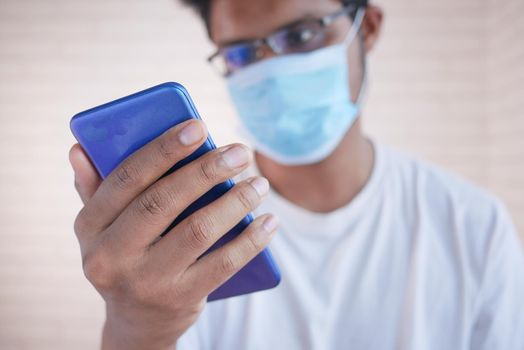sick man in surgical face mask using smart phone, selective focus ,