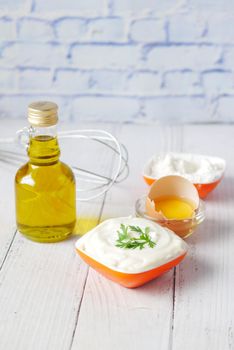 Mayonnaise in container , oil and eggs on table ,