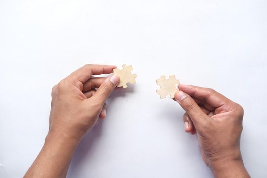 man hand hold connecting puzzle on table .