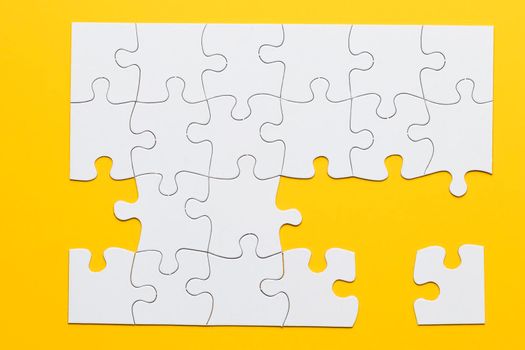 white cardboard jigsaw puzzles yellow background. High resolution photo